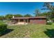 Charming single-story home with brown exterior and well-maintained front lawn on a sunny day at 1505 Ne 33Rd Pl, Ocala, FL 34479