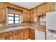 Kitchen features wood cabinets, tile floor, and white appliances at 1505 Ne 33Rd Pl, Ocala, FL 34479