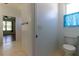 Powder room in bathroom with a toilet, tile flooring, and blue sheer curtain at 15304 Sw 15Th Terrace Rd, Ocala, FL 34473