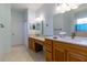 Bright bathroom featuring double sinks, light countertops, and wood cabinetry at 15304 Sw 15Th Terrace Rd, Ocala, FL 34473