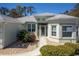 Attractive home entrance with manicured shrubbery, stone accents, and a paved walkway to the front door at 15304 Sw 15Th Terrace Rd, Ocala, FL 34473