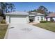 Inviting single-story home featuring a two-car garage, pristine landscaping, and decorative concrete driveway at 15304 Sw 15Th Terrace Rd, Ocala, FL 34473