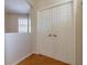 Hallway featuring hardwood floors, double closet doors, neutral paint, and natural light from the window at 15304 Sw 15Th Terrace Rd, Ocala, FL 34473