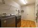 Laundry room with modern grey washer and dryer and hardwood floor at 15304 Sw 15Th Terrace Rd, Ocala, FL 34473