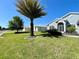 Well-manicured lawn with a large palm tree in front of the light-blue single-story home at 15702 Sw 16Th Avenue Rd, Ocala, FL 34473