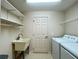 Well-equipped laundry room with utility sink, washer, dryer, and ample shelving at 15702 Sw 16Th Avenue Rd, Ocala, FL 34473