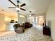 Open-concept living room with ceiling fans, a view of the kitchen and front entry at 15702 Sw 16Th Avenue Rd, Ocala, FL 34473