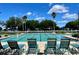 Resort-style pool with lounge chairs, palm trees, and clear blue skies, perfect for relaxing and enjoying the Florida sunshine at 15702 Sw 16Th Avenue Rd, Ocala, FL 34473