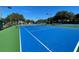 An empty blue and green tennis court on a sunny day, ready for play at 15702 Sw 16Th Avenue Rd, Ocala, FL 34473