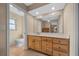 Bathroom with a large mirror, light wood cabinets, and neutral-toned tile flooring at 1732 Se 38Th Ct, Ocala, FL 34471