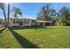 Charming single-story home features a lush green lawn, attached garage, and mature trees at 1732 Se 38Th Ct, Ocala, FL 34471