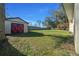 Large storage shed in the backyard with red doors, providing ample space for equipment and tools at 1732 Se 38Th Ct, Ocala, FL 34471