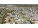 Aerial view of a large, well-maintained neighborhood with lush landscaping, and a golf course in the background at 1854 Oxford Lane, The Villages, FL 32162