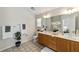 Well-lit bathroom with double sink vanity, decorative plants, and neutral decor at 1854 Oxford Lane, The Villages, FL 32162