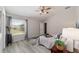 Bright bedroom featuring hardwood floors, ceiling fan, and a large window at 1854 Oxford Lane, The Villages, FL 32162