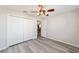 Bright bedroom features light gray wood-look floors, a ceiling fan, and a closet with bi-fold doors at 1854 Oxford Lane, The Villages, FL 32162
