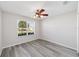 Bright, empty bedroom with stylish wood-look flooring, fan, and window at 1854 Oxford Lane, The Villages, FL 32162