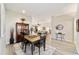 Light-filled dining area flows into the living room with gray luxury vinyl plank flooring and neutral paint at 1854 Oxford Lane, The Villages, FL 32162