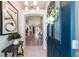 Inviting foyer featuring neutral tones, tile flooring, an elegant chandelier, and a view of the living spaces at 1854 Oxford Lane, The Villages, FL 32162