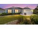 Charming home with a manicured lawn, blue shutters, and a two-car garage at twilight at 1854 Oxford Lane, The Villages, FL 32162