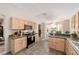 Open kitchen showcases wood cabinets, updated appliances, and a breakfast nook with natural light at 1854 Oxford Lane, The Villages, FL 32162
