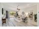 Bright living room with wood flooring, neutral decor, and sliding glass doors to the patio at 1854 Oxford Lane, The Villages, FL 32162