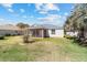 Exterior of the home features a screened in patio overlooking a well kept yard at 1854 Oxford Lane, The Villages, FL 32162