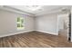 Bedroom featuring wood floors, a ceiling fan, and a window with a view of trees at 2 Hemlock Ter Dr, Ocala, FL 34472