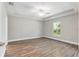 Spacious bedroom featuring wood floors, a ceiling fan, tray ceiling, and a window at 2 Hemlock Ter Dr, Ocala, FL 34472