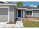 Close-up of a home's front facade, showcasing a blue front door, gray siding, and a small garden at 2 Hemlock Ter Dr, Ocala, FL 34472