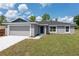 Charming single-story home featuring a gray exterior, a two-car garage, and a well-maintained lawn at 2 Hemlock Ter Dr, Ocala, FL 34472