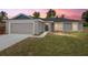 Charming front exterior of the home at sunset featuring a well-manicured lawn at 2 Hemlock Ter Dr, Ocala, FL 34472
