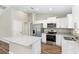 Bright kitchen with stainless steel appliances, granite countertops, and white cabinetry at 2 Hemlock Ter Dr, Ocala, FL 34472