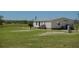 The rear of a home is surrounded by a lush, green lawn and highlighted by the metal roof at 2061 Nw 165Th Court Rd, Dunnellon, FL 34432
