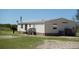 A view of the back exterior of a well-maintained home with a metal roof and a small palm tree at 2061 Nw 165Th Court Rd, Dunnellon, FL 34432