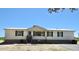 A single-story home with a white exterior, dark shutters, and a metal roof, set in a rural area at 2061 Nw 165Th Court Rd, Dunnellon, FL 34432
