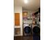 Well-lit laundry room with front-loading washer/dryer set, shelves, and cabinet at 2061 Nw 165Th Court Rd, Dunnellon, FL 34432