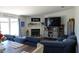 Inviting living room with a plush blue sectional sofa, fireplace, and modern entertainment center at 2061 Nw 165Th Court Rd, Dunnellon, FL 34432