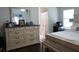 Spacious main bedroom featuring a queen bed, dresser, mirror, and a doorway to an en-suite bathroom at 2061 Nw 165Th Court Rd, Dunnellon, FL 34432