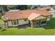 Back exterior view featuring a spacious yard, screened lanai, and a well-kept lawn with mature landscaping at 22 Banyan Dr, Ocala, FL 34472