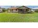 Spacious backyard featuring lush green grass, a screened lanai and a well maintained light-colored exterior at 22 Banyan Dr, Ocala, FL 34472