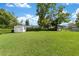 Spacious backyard with a storage shed, mature trees, and a well-kept lawn perfect for outdoor activities at 22 Banyan Dr, Ocala, FL 34472