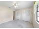 Bright bedroom features neutral carpet, a ceiling fan, and a double-door closet for ample storage at 22 Banyan Dr, Ocala, FL 34472
