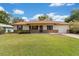 Charming single-story home with a green lawn, classic brick accents, and attached garage at 22 Banyan Dr, Ocala, FL 34472