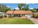 Charming home featuring a well-maintained lawn, brick accents, and a cozy front porch at 22 Banyan Dr, Ocala, FL 34472