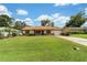 Inviting single-story home with a lush green lawn, mature trees, and a classic suburban appeal at 22 Banyan Dr, Ocala, FL 34472