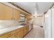 Bright kitchen with light wood cabinets, tile flooring, and a view of the backyard through the window over the sink at 22 Banyan Dr, Ocala, FL 34472