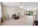 Open-concept living room with tile flooring, ceiling fan, and sliding glass doors to the lanai at 22 Banyan Dr, Ocala, FL 34472