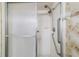 Walk-in shower featuring dual shower heads, a grab bar, built-in soap dish, and a glass shower door at 22 Banyan Dr, Ocala, FL 34472