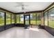 A bright sunroom features multiple windows offering views of the backyard and a ceiling fan for added comfort at 22 Banyan Dr, Ocala, FL 34472